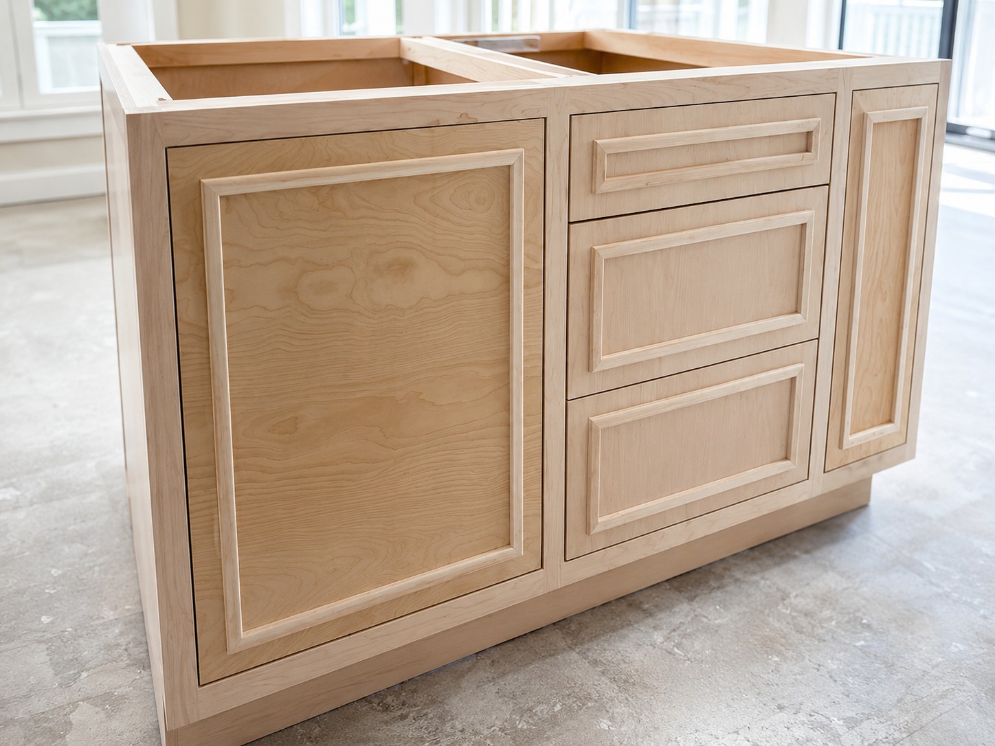 Close detail of the bare maple cabinet doors and drawer fronts before priming