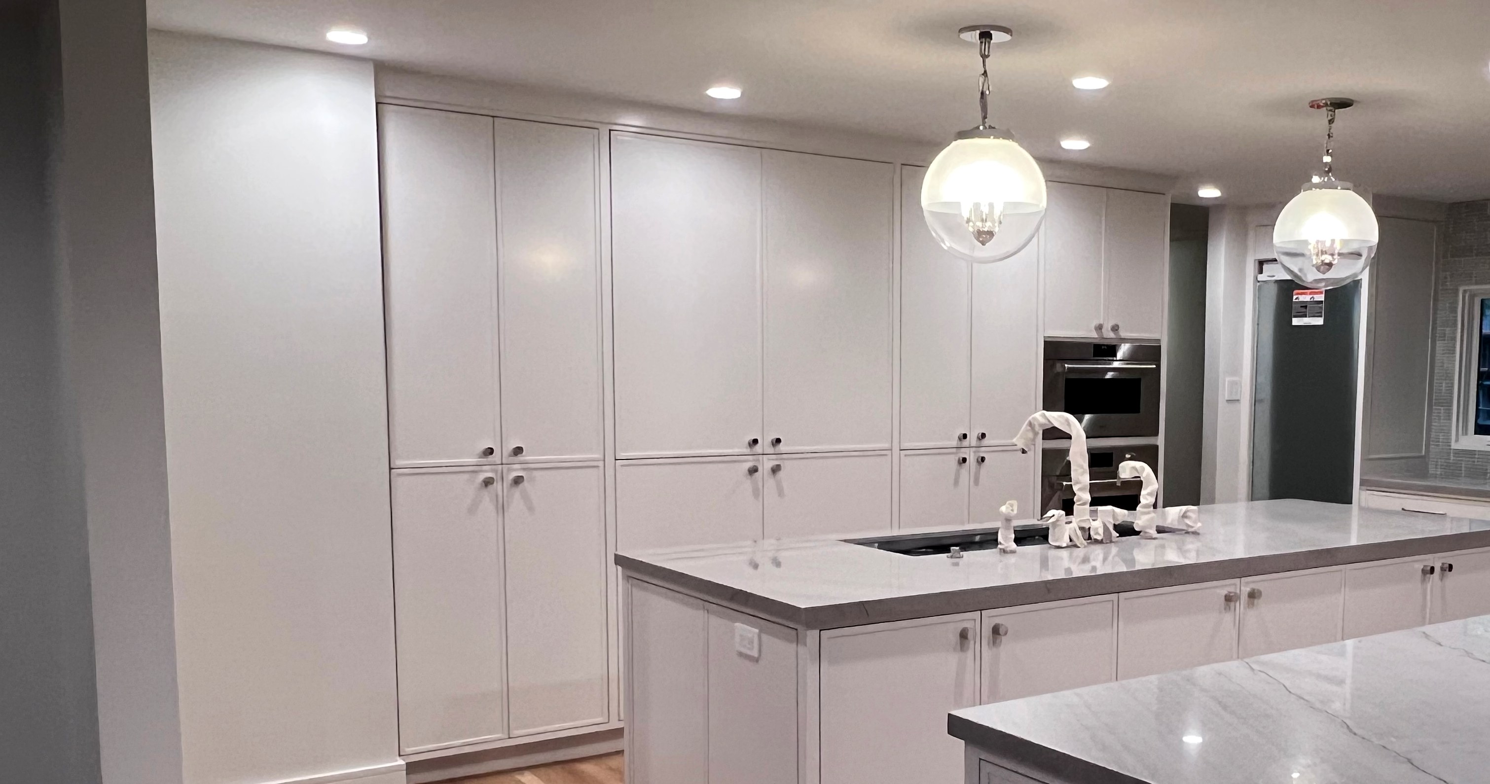 Pale cabinetry and kitchen islands during finishing work.