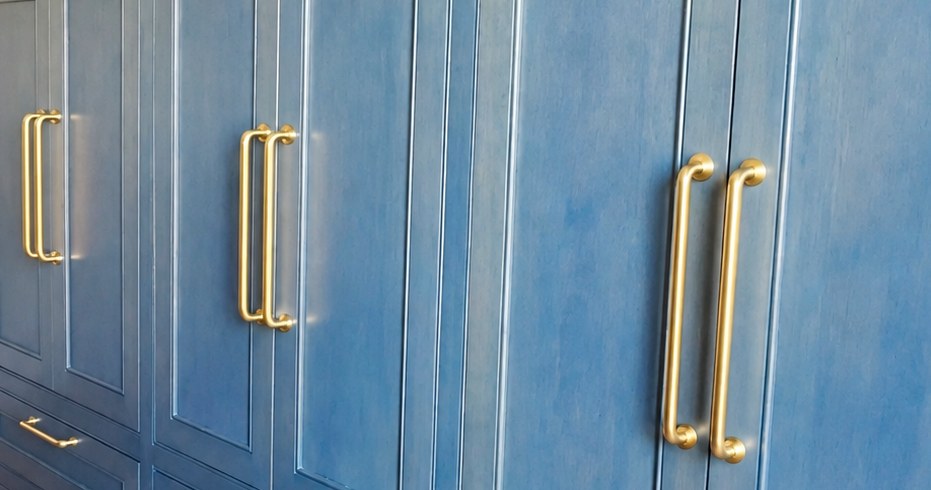Blue cabinetry with visible wood grain, paneled doors and brass handles.