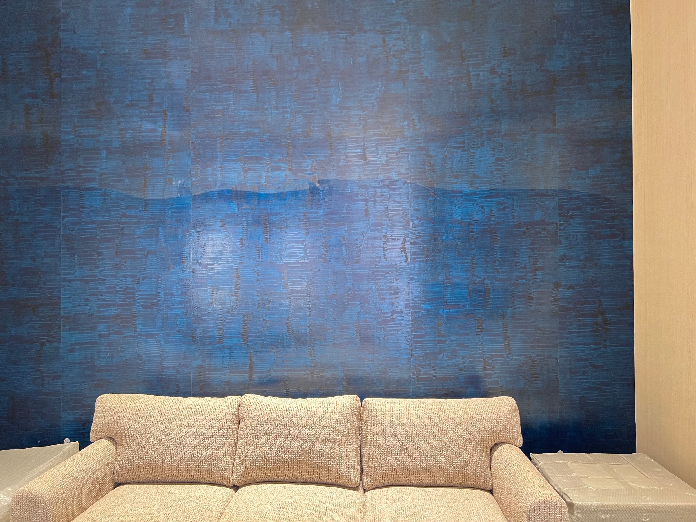 Finished blue textured feature wall behind a light-colored sofa.