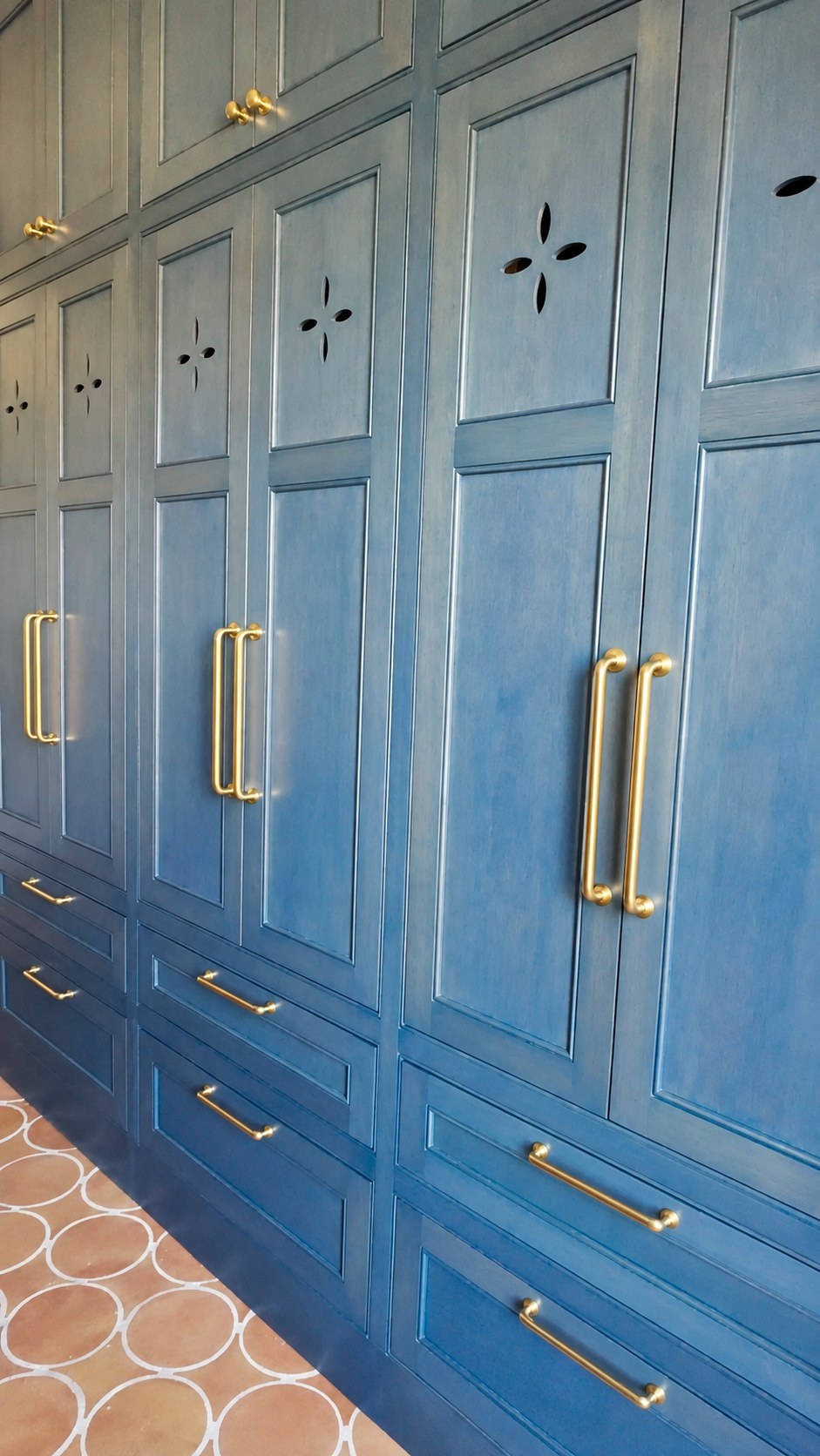 Custom blue stain and clear coat on oak built-ins, with brass hardware.