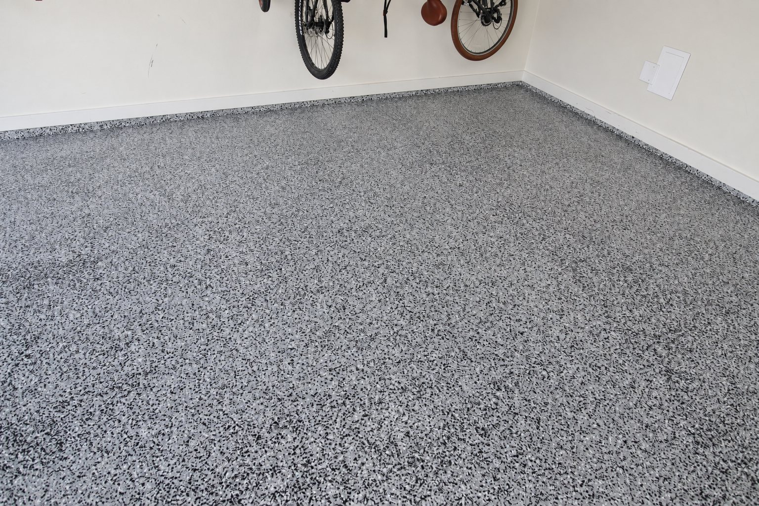 Gray speckled garage floor with a textured finish.