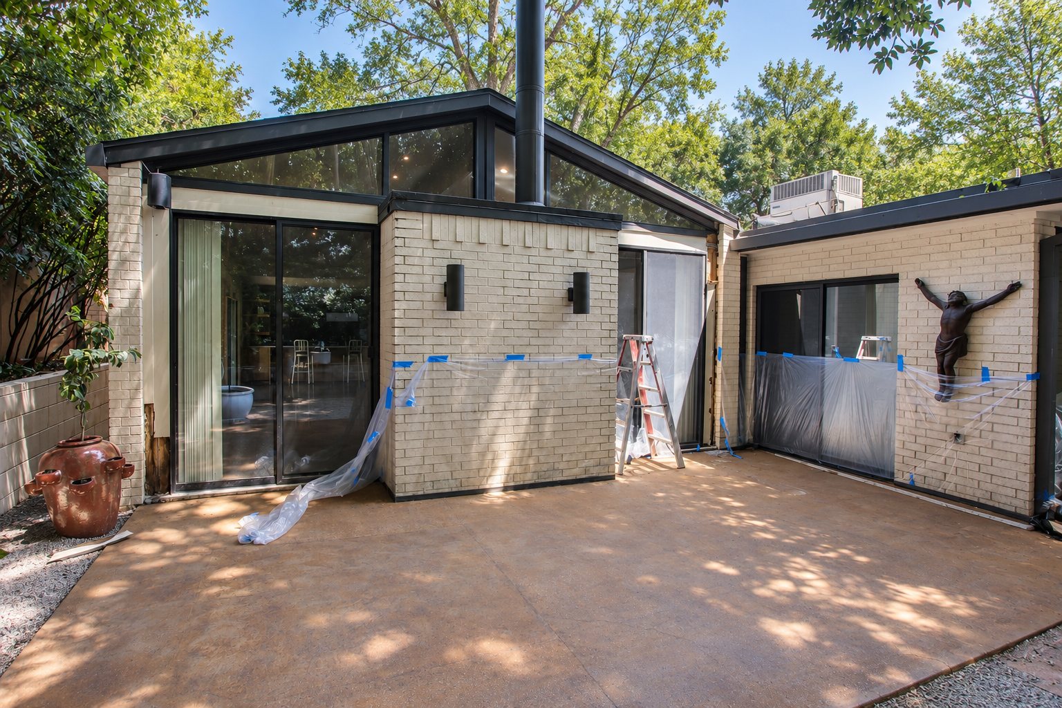 Light brick courtyard and dark trim during exterior preparation.