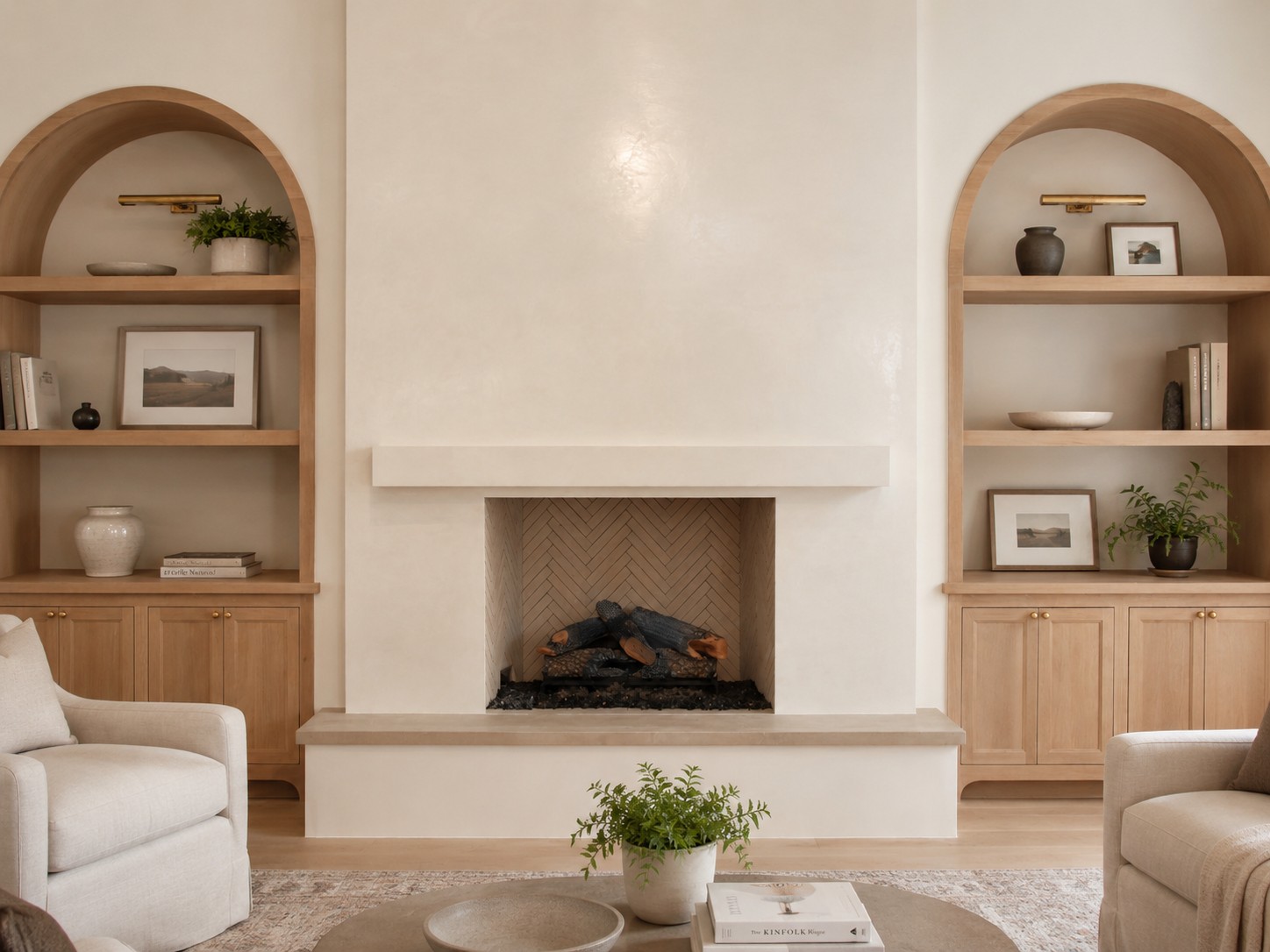 Cream plaster fireplace framed by arched wood shelves and cabinets.